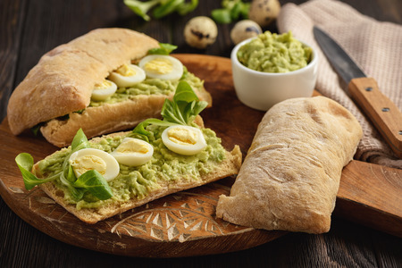 Avocado sandwich ciabatta with quail eggs.の写真素材