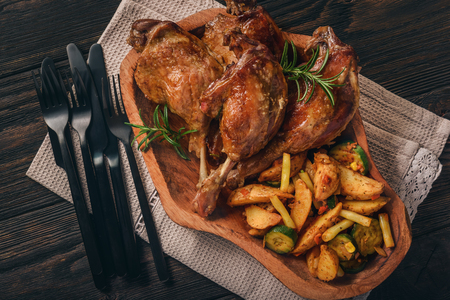 Roasted duck legs with apples and cranberries, served with vegetables.の写真素材