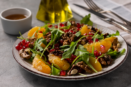 Arugula salad with oranges, walnuts and pomegranate.の写真素材