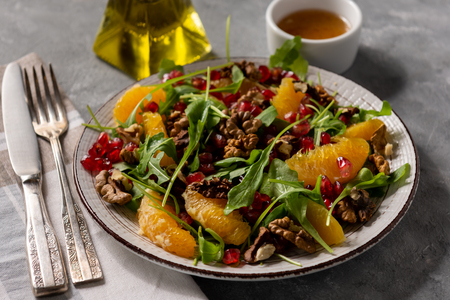 Arugula salad with oranges, walnuts and pomegranate.の写真素材