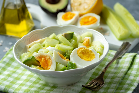 Healthy vegetarian salad with avocado, eggs and cucumbers.の写真素材