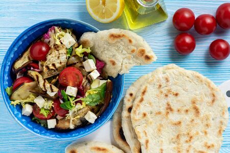 Grilled eggplant, tomatoes and feta cheese salad with flatbread, mediterranean cuisine.の写真素材