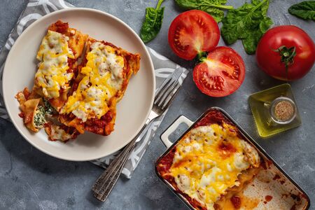 Spinach and ricotta stuffed cannelloni baked in tomato sauce.の写真素材