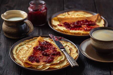 Homemade crepes with berry jam and cup of coffee.の写真素材