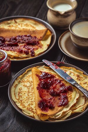 Homemade crepes with berry jam and cup of coffee.の写真素材
