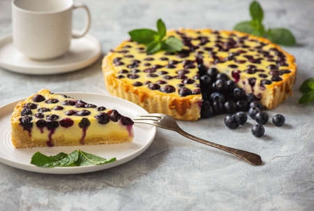 Cheesecake with blueberries and mint on a light background.の写真素材