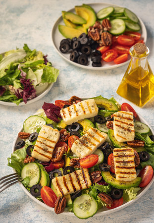 Greek style cuisine - salad with grilled halloumi cheese, avocado, pecan nuts and tomatoes.の写真素材