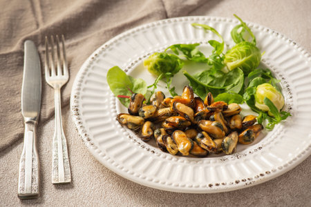 Mussels cooked in coconut oil served with greens and Brussels sproutsの写真素材