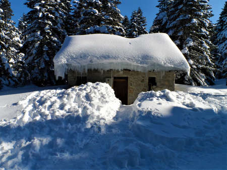 a stone house immersed in snow and iceの写真素材