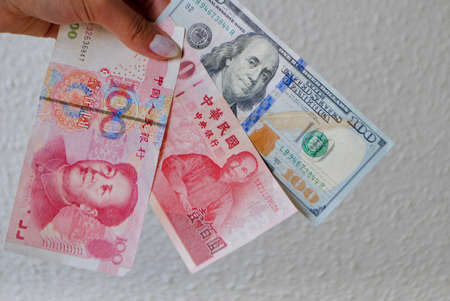 emale fingers hold green and red money banknotes of leaders portraits of United States of America, Taiwan and China . US China Cold War. World political war concept.の写真素材