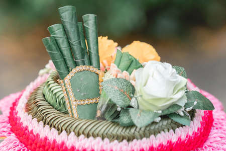 Decorated cake with flowers and green leaves on the tableの写真素材