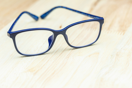 Blue eye glasses on wood table for business, education concept design.の写真素材