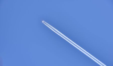 An airliner passes high in the sky flying over the Dolomites