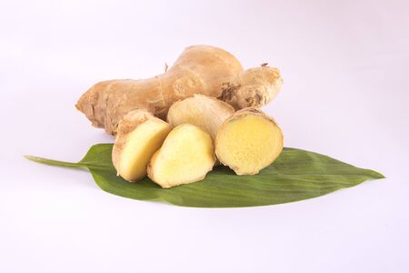 slices ginger root with leaves isolated on white backgroundの写真素材