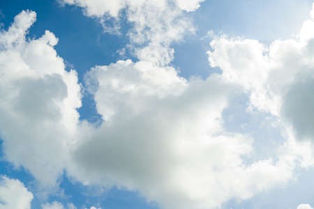The gray and white clouds floating under a blue sky, stirred by the winds, which shape them in curious shapes.の写真素材