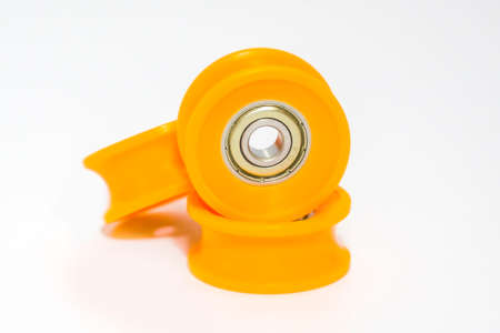 Pulley and reel plastic bearings wheel yellow color isolated on white background. Pulley for industry, yellow reel, hanging, equipment, rackの写真素材