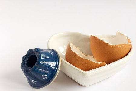 Photo of broken egg shell in the bowl on the white background.の写真素材