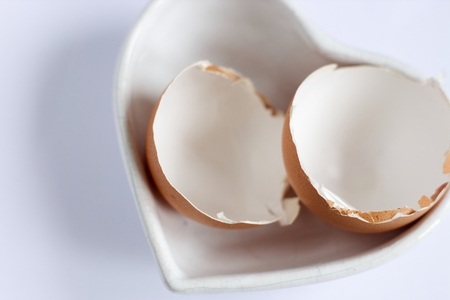 Photo of broken egg shell in the bowl on the white background.の写真素材