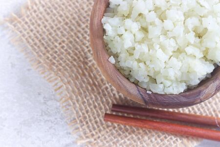 Photo of Homemade Healthy Vegetarian Cauliflower Rice in Wooden Bowl.の写真素材
