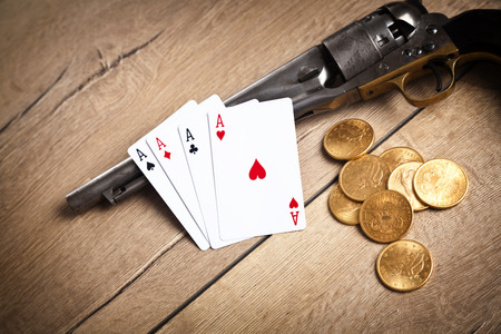 gambling and crime concept with gun, cards and golden coins