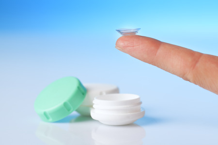 contact lens on finger and case on blue backgroundの写真素材
