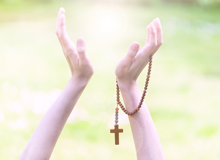 Hands of a Woman Praying with Rosary