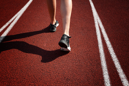 Runner feet running on racetrack closeup on shoe