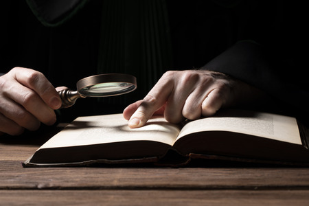 Criminal or tax investigation concept. Hand with detective magnifying glassの写真素材