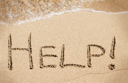 Help handwritten on sand of beach with wave on backgroundの写真素材