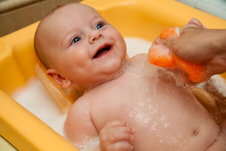 4 month old boy having fun and smiling in bathtime