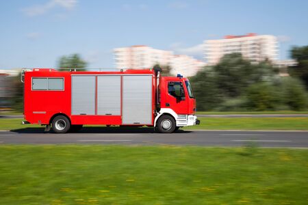 Panning image of a fire truck rushing on the street in intentional motion blur