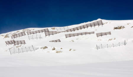 Avalanche barriers protecting ski slopes in alps mountainsの写真素材