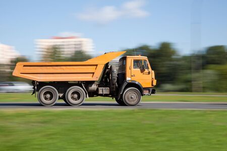 Panning image of yellow truck in intentional motion blur