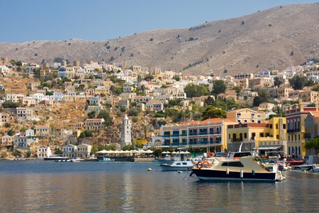 Boats in bay and houses on symi island, greece