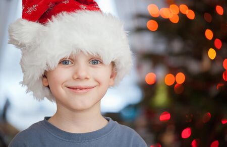 Boy in santa claus hat having fun in christmas dayの写真素材