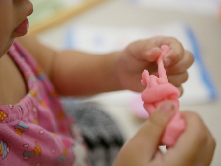 Selective focus of Asian baby's hands playing play doughの写真素材