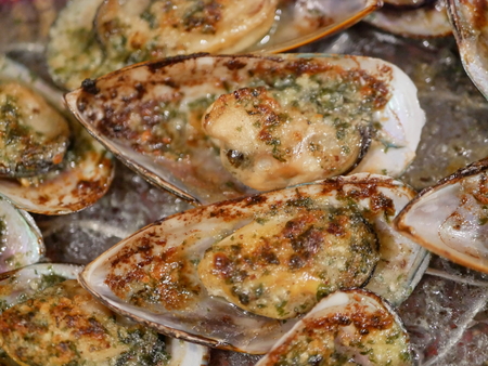 Selective focus of hot fresh baked mussels with butter and garlic from an ovenの写真素材