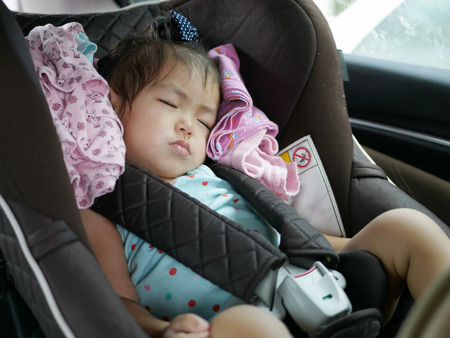 Little Asian baby girl, 18 months old, sleeping on a car seat for baby safetyの写真素材