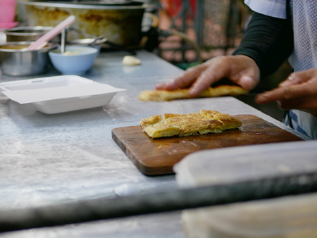 Crisp fresh chopped roti being put in a box getting ready to be served - delicious street food in Thailandの写真素材