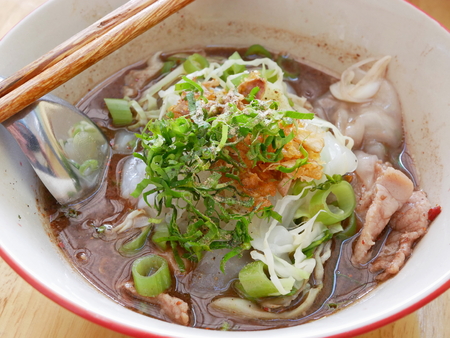 Closeup of fresh spicy noodles soup with pork and its tasty made-of-pig-blood thick broth (Guay Tiao Rua) - delicious and healthy street food in Thailandの写真素材