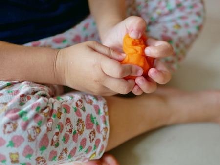 Close up of little baby's hands squeezing playdough - playing dough promotes baby's creativity, imagination, and fine motor skill developmentの写真素材