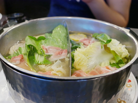 Cooking hotpot (Shabu-shabu) with a bunch of vegetables and meat in the pot - famous get-together meal in Thailand, among the locals, for a group of people or familyの写真素材