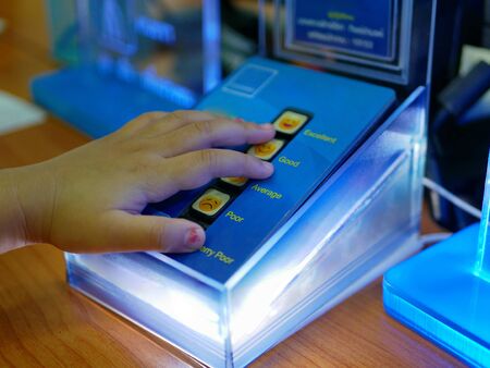 Little baby's hand on a push button feedback device for customer's satisfaction evaluationの写真素材