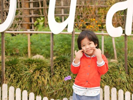 Little Asian baby girl, 38 months old, smiling and making a cute funny gestureの写真素材