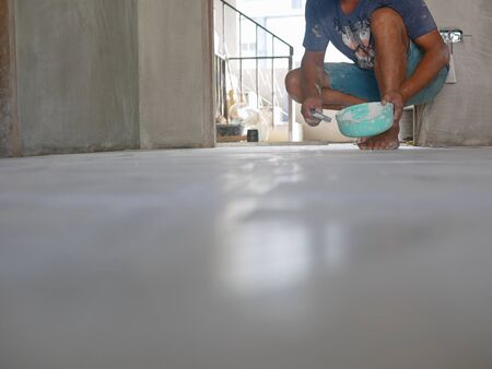 A construction worker grunting the ceramic tile floor - tiling workの写真素材