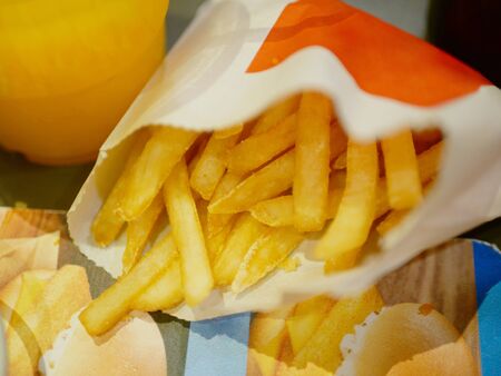 Closeup of crispy golden french fried in a paper bag ready to be eatten 