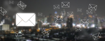 Concept of Email Communication and Connectivity: Postal Envelopes and Emails on Defocused Cityscape Backgroundの写真素材