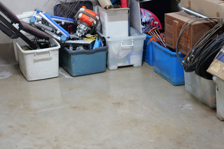 Water spreading. flooding on storage room concrete floor in a house - damage on belongings caused by...