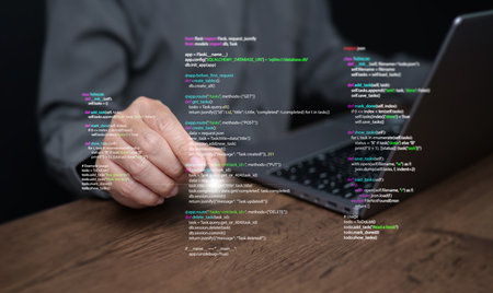 Hands of a programmer types on a laptop displaying programming code, symbolizing coding tech, software development, web applications. IT solutions, and digital technologyの写真素材