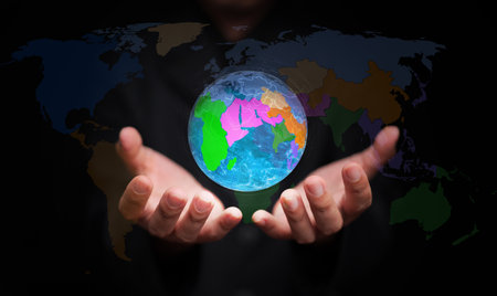 Businessman holding holographic Earth with colorful regions symbolizes regionalism, economic cooperation, and strategic partnership in the global market.の写真素材